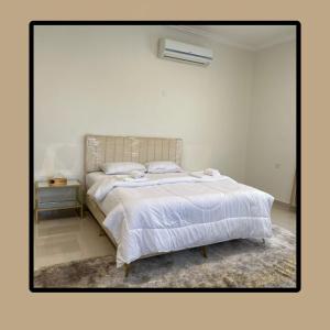 ein weißes Schlafzimmer mit einem Bett mit einer weißen Decke in der Unterkunft Homely.8 شقة in Firq
