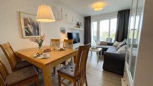 eine Küche und ein Wohnzimmer mit einem Tisch und einem Sofa in der Unterkunft Strandhaus Nordseebrandung Fewo A2.4 in Cuxhaven