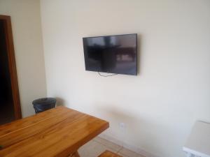 沙帕達－杜斯吉馬朗伊斯的住宿－Sobrado espaçoso com piscina com ar na suite，挂在白色墙壁上的平面电视