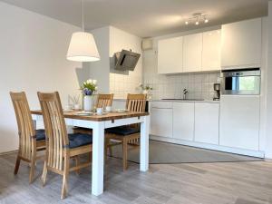 una cucina e una sala da pranzo con tavolo e sedie di Strandhaus-Nordseebrandung-Fewo-A3-2 a Cuxhaven