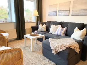un soggiorno con divano blu e tavolo di Strandhaus-Nordseebrandung-Fewo-A3-2 a Cuxhaven