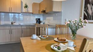 eine Küche mit einem Tisch mit zwei Tellern Essen drauf in der Unterkunft Strandhaus Nordseebrandung Fewo B1.4 in Cuxhaven