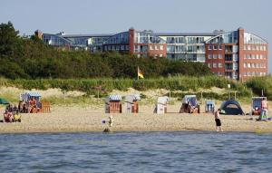 ein Strand mit einer Gruppe von Menschen am Strand in der Unterkunft Strandhaus Nordseebrandung Fewo B1.4 in Cuxhaven