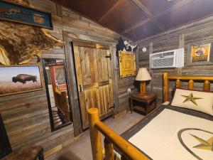 1 dormitorio con 1 cama en una cabaña de madera en Buffalo Girls Hotel, en Canton