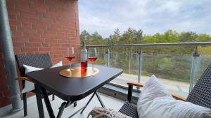 einen Tisch mit zwei Gläsern Wein auf dem Balkon in der Unterkunft Strandhaus Nordseebrandung Fewo A2.2 in Cuxhaven
