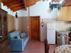 een woonkamer met een blauwe bank en een keuken bij Casa de Santa Luzia B in Caminha