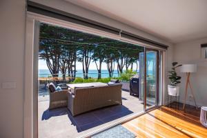 een woonkamer met een glazen schuifdeur naar een patio bij Luxurious 4 Bedroom House with Stunning Beach view in St Leonards in Saint Leonards