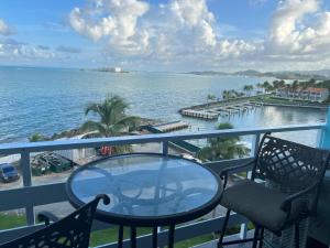 a balcony with a table and chairs and the ocean at Marina Lanais 609 in Fajardo