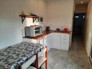 a small kitchen with a table and a microwave at Atardecer Serrano in Sierra de la Ventana
