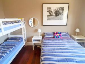 a bedroom with two beds and a bunk bed at Bellingen Belfry Guesthouse in Bellingen