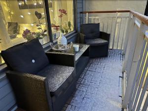 eine Terrasse mit 2 Stühlen und einem Tisch auf dem Balkon in der Unterkunft Central and cozy next to Oslo S in Oslo