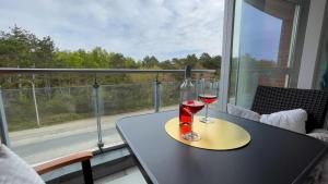 einen Tisch mit zwei Gläsern Wein auf dem Balkon in der Unterkunft Strandhaus Nordseebrandung Fewo A1.2 in Cuxhaven