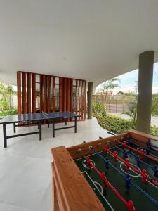 ein Raum mit zwei Tischtennisplatten und einem Billardtisch in der Unterkunft Flat ESTUDIO de LUXO - Praia de Muro Alto - Piscinas - Ideal para CASAIS, famílias com crianças - ap COMPLETO - AR COND, WI FI, NETFLIX, ESTACIONAMENTO - 400 mt do MAR in Porto De Galinhas