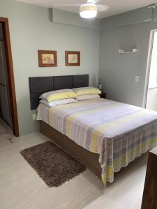 En eller flere senge i et værelse på Apartamento Confortável