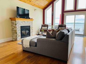 a living room with a couch and a fireplace at SouthLake Cottage on The Lake. in Washago