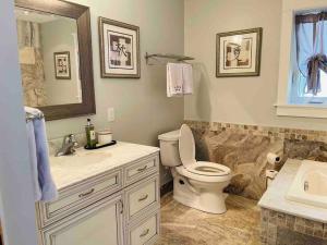 a bathroom with a toilet and a sink and a mirror at SouthLake Cottage on The Lake. in Washago +37 photos