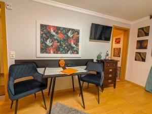 Zimmer mit einem Tisch, 2 Stühlen und einem Gemälde in der Unterkunft Erholungskellerchen in Bad Lippspringe