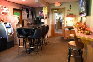 a bar with a row of stools in a restaurant at Campus Inn Baraboo in Baraboo