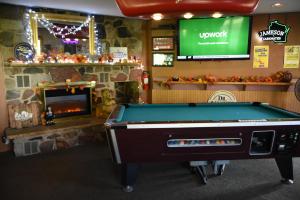 a pool table in a room with a fireplace at Campus Inn Baraboo in Baraboo
