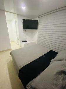 a bedroom with two beds and a flat screen tv at Casa en condominio Bahia Solero - Torrosa in Ricaurte