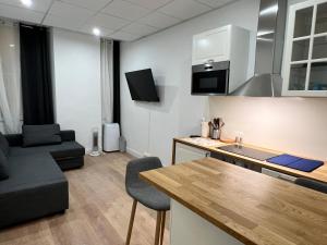 kuchnia i salon z kanapą i stołem w obiekcie Studio Climatisé Centre Ville #9 w mieście Tulon