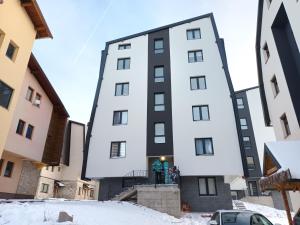 a tall white building in the snow at Acero Verde Jahorina in Jahorina