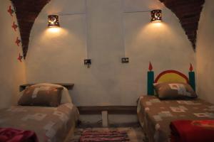 Carmah Guest house في أسوان: غرفة نوم بسريرين في غرفة