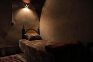 Carmah Guest house في أسوان: غرفة مظلمة مع سرير وضوء