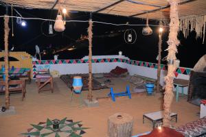 um quarto com uma tenda com cadeiras e baloiços em Carmah Guest house em Aswan