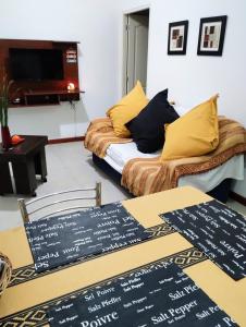 ein Zimmer mit einem Sofa und einem Tisch mit Schildern darauf in der Unterkunft Cabañas Montoya in Paraná