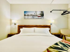 キャンモアにあるJoes Brand New 2 King Bedrooms Townhome in Canmoreのベッドルーム(大きな白いベッド1台、椅子付)