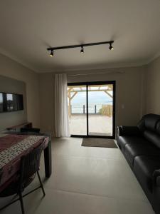 uma sala de estar com um sofá e vista para a praia em APARTAMENTO BEIRA MAR EM BALNEÁRIO PEREQUÊ em Porto Belo