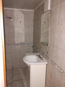 y baño con lavabo y ducha con espejo. en Departamentos Centro Dpto 5 1 habitacion en Tandil