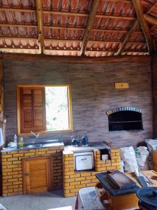 a kitchen with a stove and a fireplace at Pousada Canever in Lauro Müller