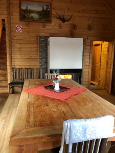 a large wooden table in a room with a fireplace at Maja saunaga in Rõmeda