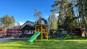 un parque infantil frente a un edificio con tobogán en Maja saunaga, en Rõmeda