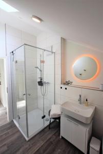 een badkamer met een glazen douche en een wastafel bij Meeresblick-Strandkieker-Haus-3-WE-45 in Hohwacht
