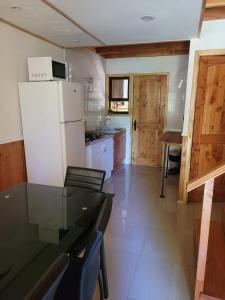 a kitchen with a refrigerator and a table and chairs at Townhouse Millatray in Caburgua
