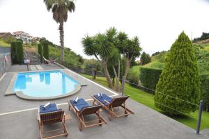 a swimming pool with lounge chairs next to at Quinta do Brasil in Ribeira do Raposo