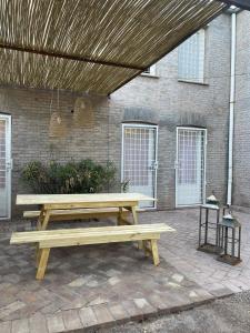 a wooden picnic table in front of a brick building at Casablanca Chacras in Chacras de Coria