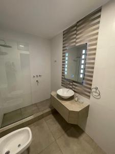 a bathroom with a sink and a toilet and a tub at Casablanca Chacras in Chacras de Coria