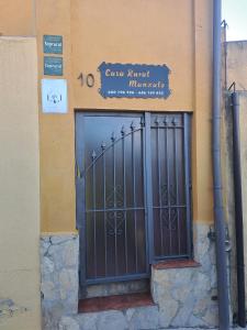 une porte d'entrée d'un bâtiment avec un panneau au-dessus de celui-ci dans l'établissement Manxalo, à Sant Mateu