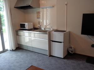 a small kitchen with a sink and a microwave at Villa House Hisago - Vacation STAY 61410v in Kawazu