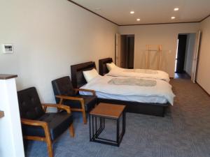 een slaapkamer met een bed en 2 stoelen en een tafel bij Villa House Hisago - Vacation STAY 03175v in Kawazu