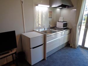 een kleine keuken met een wastafel en een magnetron bij Villa House Hisago - Vacation STAY 03175v in Kawazu