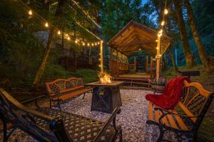 a backyard with benches and a fireplace and a house at Voted #1 Cabin in Smokys! Spa, Arcade, Private, Creek, King Beds in Sevierville