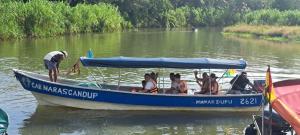 een groep mensen in een blauwe boot op een rivier bij Cabañas Narasgandup (Naranjo Chico) in Mamartupo