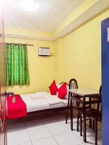 Habitación pequeña con cama y mesa en YellowPad Hotel (SM-Eco) en Dávao