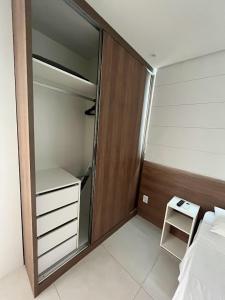 a bedroom with a closet and a bed and a table at Flatsportojjp - Flat Cupe Beach in Porto De Galinhas