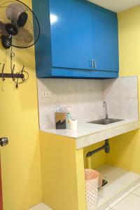 cocina con fregadero y armario azul en YellowPad Hotel (SM-Eco) en Dávao